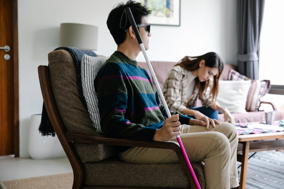 Uomo non vedente seduto in poltrona con bastone bianco e rosa, conversione libbre kg e calcolo del peso