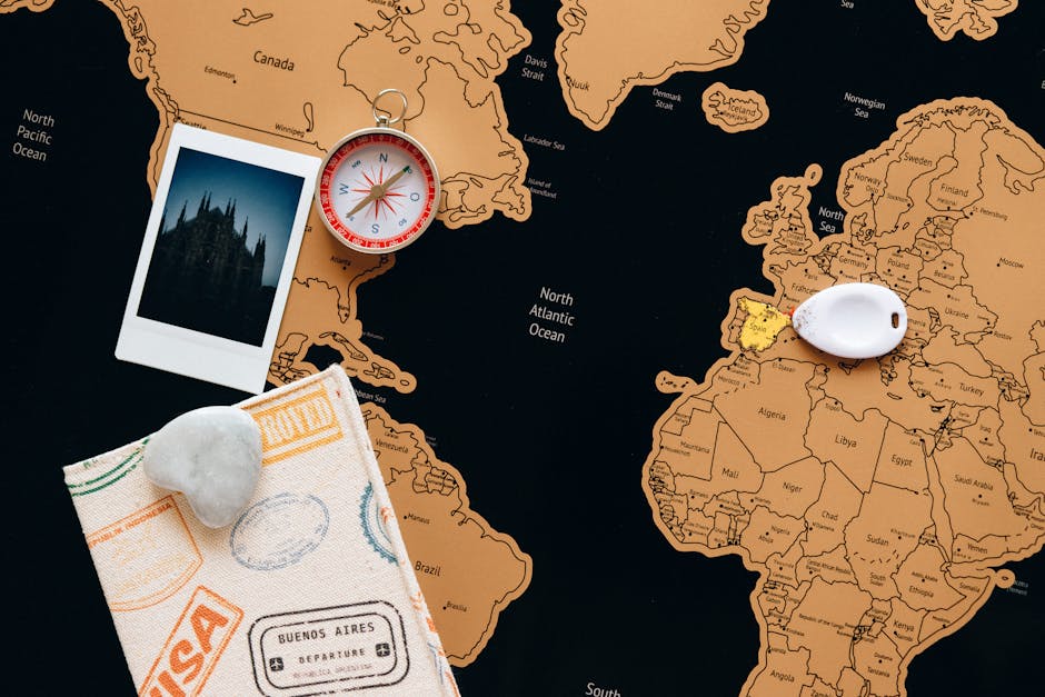 Mappa del mondo con bussola, polaroid di architettura gotica, passaporto con visti e pietra a forma di cuore, ispirazione viaggio e scoperta.