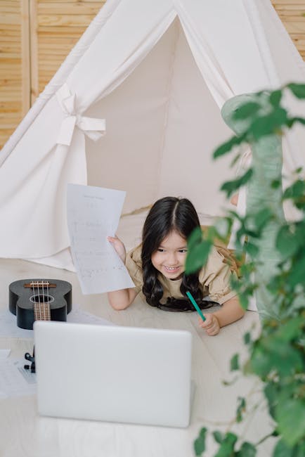 Bambina sorridente impara musica online con ukulele e spartito in tenda, attività musicali divertenti per bambini