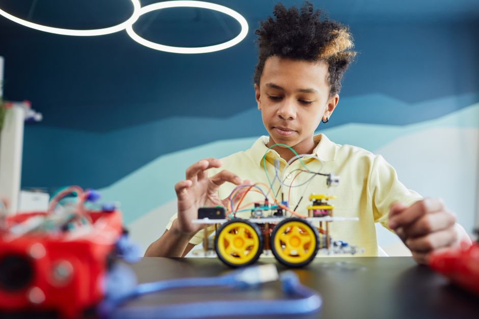 Studente di scuola media che costruisce un robot con componenti elettronici, simbolo dell'apprendimento dell'intelligenza artificiale e della scadenza del 2 agosto 2026.