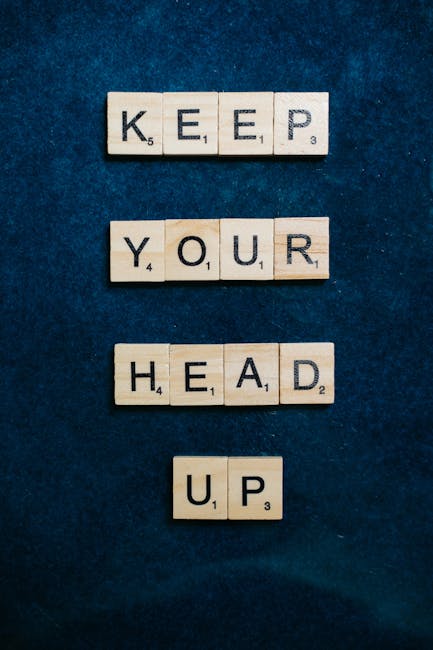 Tessere di Scrabble che compongono la frase Keep Your Head Up, metafora di resilienza e positività per arricchire il linguaggio con aggettivi R.