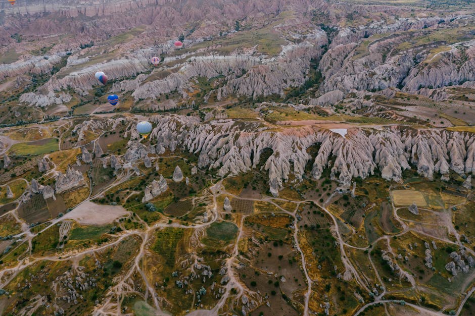 Paesaggio mozzafiato della Cappadocia con mongolfiere che fluttuano sopra le formazioni rocciose uniche, evocando un senso di libertà e avventura.