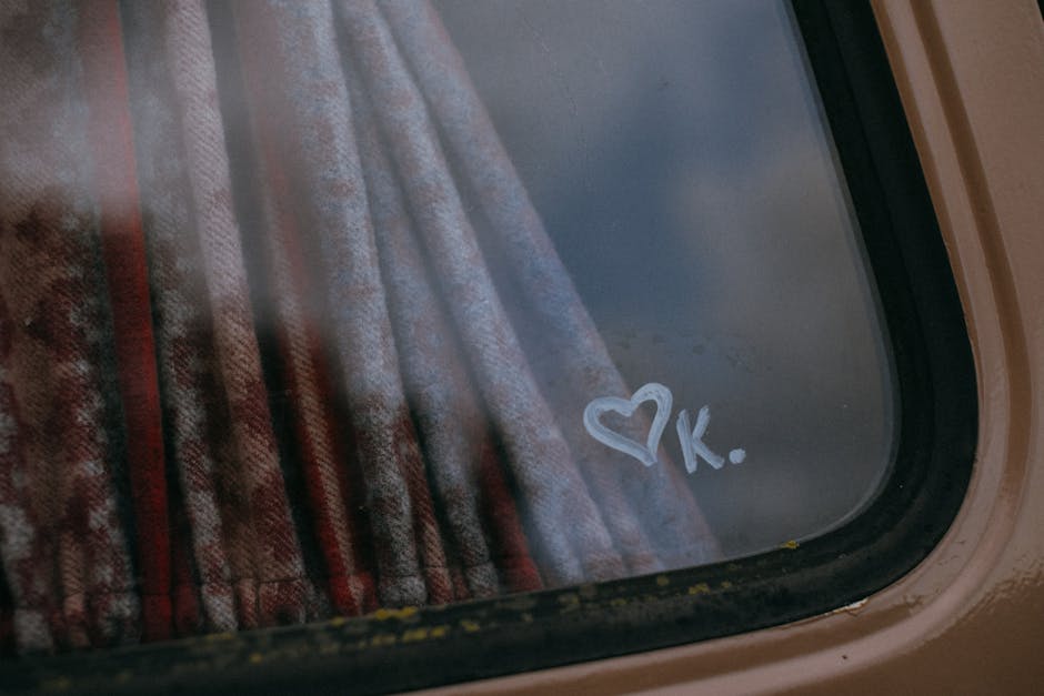 Cuore e lettera K disegnati sul vetro di un'auto, simbolo di affetto e ricordo, per le schede didattiche sulla Costituzione Italiana.