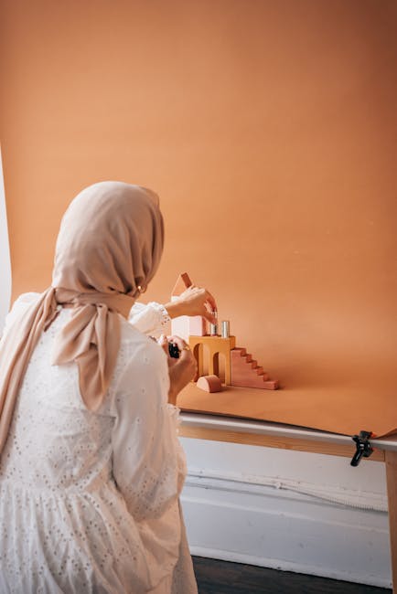 Donna con hijab fotografa composizione di oggetti su sfondo arancione, metafora visiva per contestazioni concorso docenti PNRR
