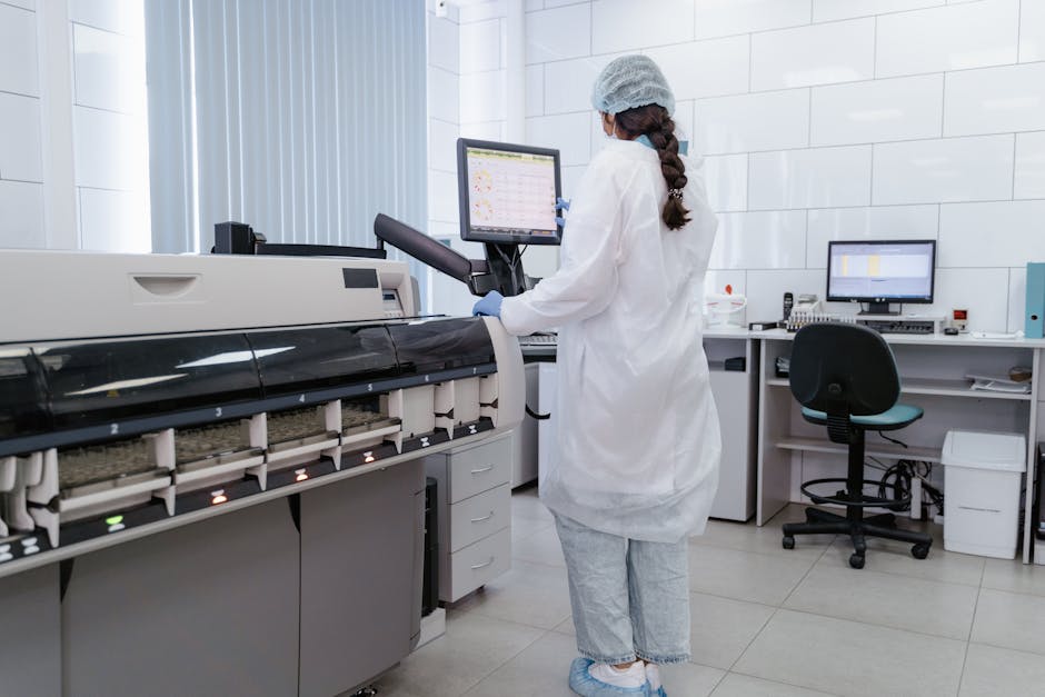 Funzioni strumentali: tecnico di laboratorio al lavoro con analizzatore automatico per esami clinici e monitoraggio dati