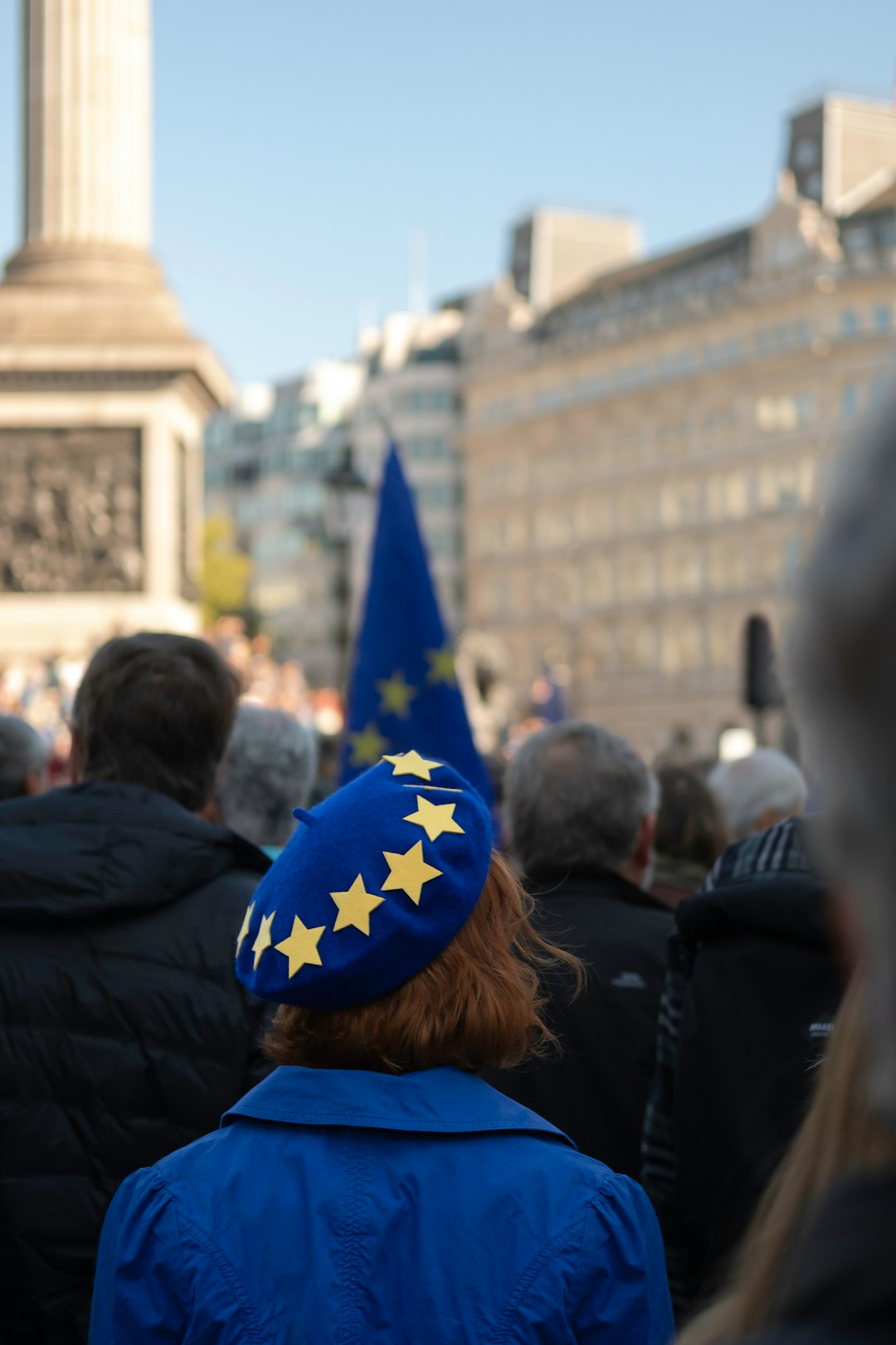 Donna con berretto blu decorato con stelle gialle dell'Unione Europea, simbolo di appartenenza europea e del lavoro nella cultura, in un contesto di dibattito sul divario occupazionale in Italia.