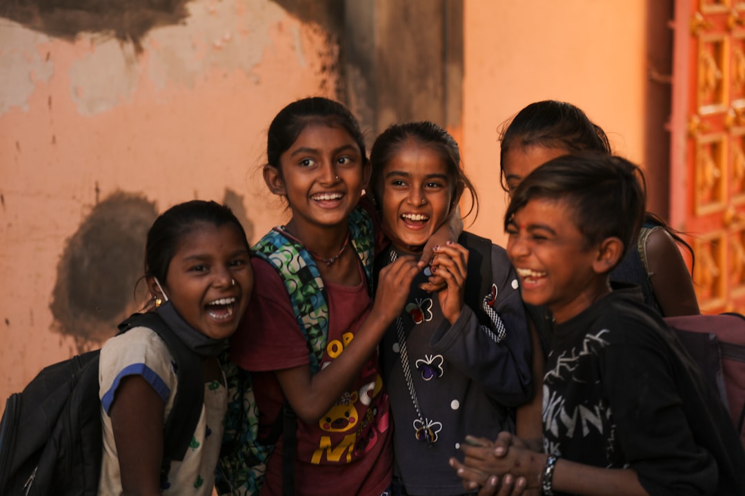 Gruppo di bambini indiani sorridenti e felici, simbolo di amicizia e inclusione premiata in progetti scolastici per abbattere barriere.